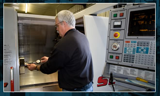 Worker at a CNC machine in the Iowa Tool & Manufacturing shop